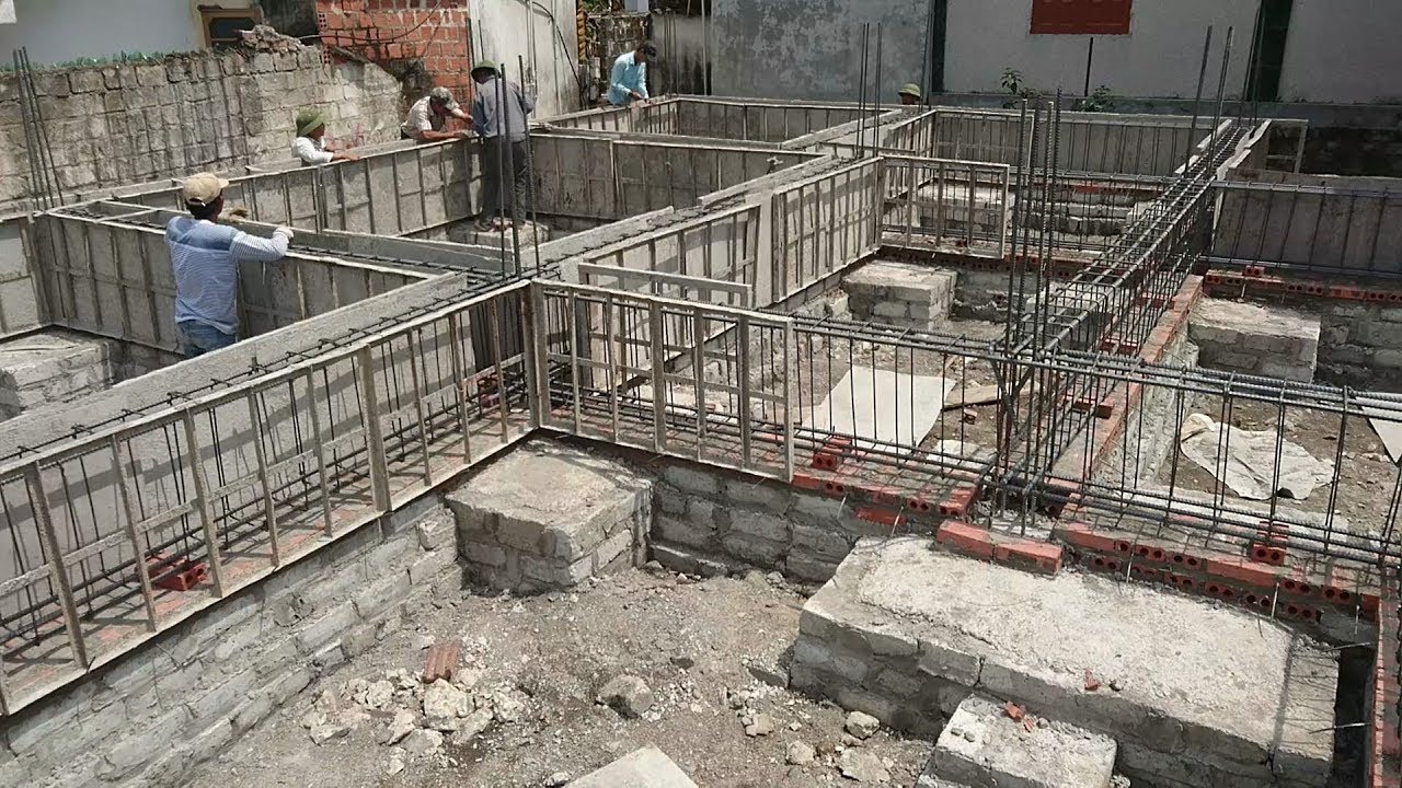 Cốp pha và thép giằng móng đang được lắp trên các khối móng đá hộc tại một công trình nhà dân